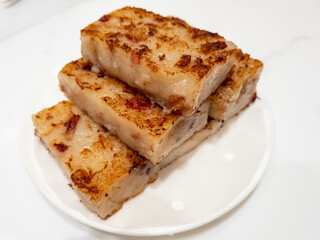 A full plate of turnip cake or lo bak go in Cantonese isolated on a marble background.