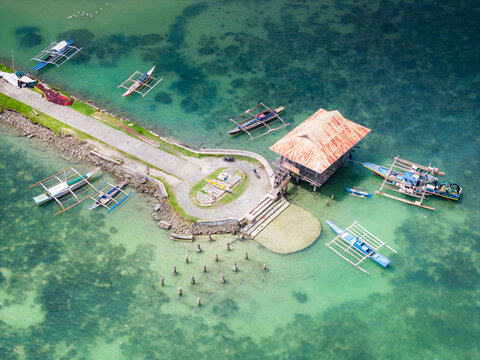 Traditional Filipino boat dock in Dauis town in Panglao, Bohol island of Philippines. Aerial drone view of traditional philippinese boats at port
