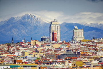 Panoramic view of Madrid, the capital of Spain, with the partially snow-covered mountains in the background.