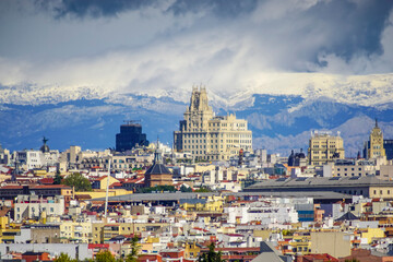 Panoramic view of Madrid, the capital of Spain, with the partially snow-covered mountains in the background.