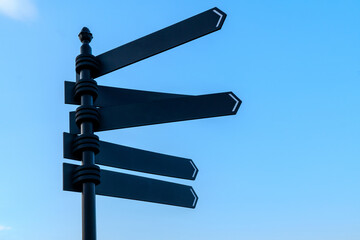 Empty signpost against clear blue sky