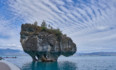 The Marble Caves in General Carrera Lake in Chile, rock formations with curved walls covered in unique patterns. Reflected blue light from turquoise water. Exploring the caves by boat or kayak tour.