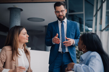 Businessman leading meeting with diverse team in modern office