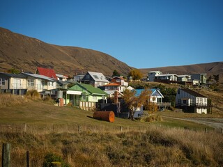 Typical New Zealand architecture house buildings at Lake Clearwater Village Town summer destination on golden grass hills, Ashburton Lakes Canterbury