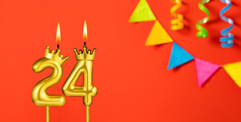 Number 24 birthday candle on an orange background with pennants