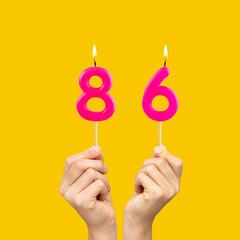 Birthday number 86 - Hands holding fuchsia colored candles