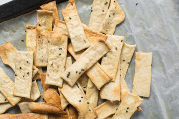 Overhead view of homemade crackers, top view of freshly baked black sesame cracker biscuits,...