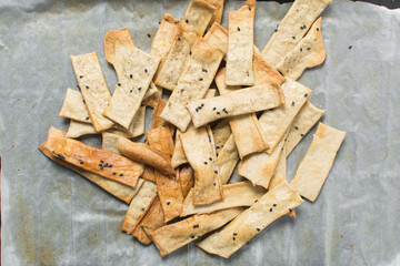 Overhead view of homemade crackers, top view of freshly baked black sesame cracker biscuits, process of making crackers