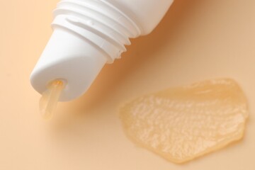 Tube of moisturizing lip balm on beige background, top view