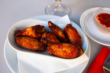 Appetizing crispy deep fried chicken wings served on plate. Popular snack