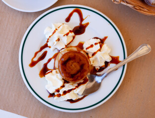 Traditional french dessert creme caramel or flan decorated with whipped cream