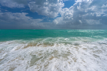 Ocean waves background. Tropical ocean waves. Blue seaside view. Foamy beach coastline. Sandy shore backdrop. Summer travel and vacation. Blue sea beach wave.