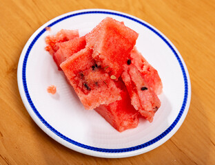 Ripe watermelon divided in pieces served in a plate with necessary table laying