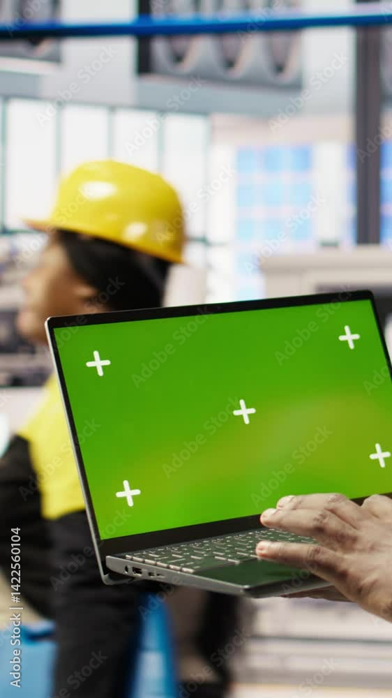 Poster vertical video smart factory mechanic testing automated systems using isolated screen laptop, doing 