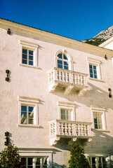 Ancient stone three-story house with balconies at the foot of the mountains