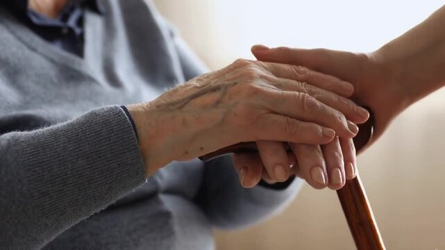Supportive Hand on Elderly Person's Walking Stick &ndash; Compassion, Care, Senior Help Concept