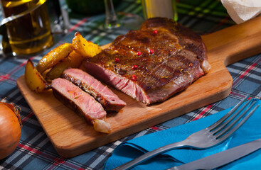 Appetizing deep-fried beef with potato served on cutting board