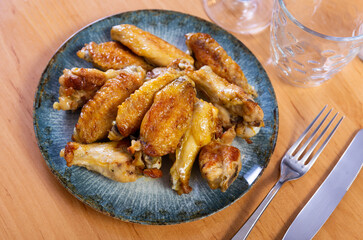 There is hearty snack on plate - large portion of fried chicken wings. High quality photo
