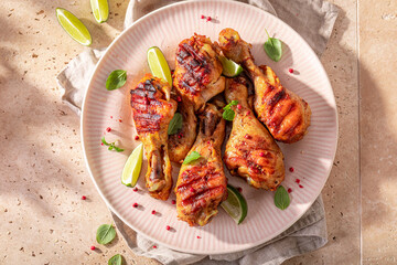 Tasty roasted chicken leg served with lime and herbs.