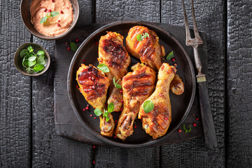 Tasty roasted chicken leg with sauces and lime.