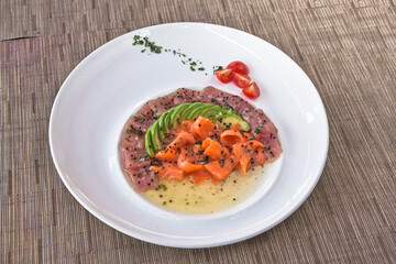 Tuna and salmon carpaccio with avocado and sesame seeds, salmon and tuna tiradito, food