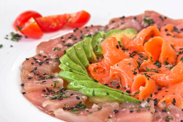 Tuna and salmon carpaccio with avocado and sesame seeds, salmon and tuna tiradito, food