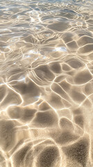 Sunlight dancing on clear water at a serene beach during the afternoon