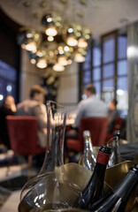 Champagne tasting, Wine glasses are on the table, stylish table setting, wine is poured from a bottle and decanter, sparkling wine bubbles, snacks, people smell the aroma and taste the wine