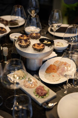 Champagne tasting, Wine glasses are on the table, stylish table setting, wine is poured from a bottle and decanter, sparkling wine bubbles, snacks, people smell the aroma and taste the wine