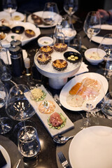 Champagne tasting, Wine glasses are on the table, stylish table setting, wine is poured from a bottle and decanter, sparkling wine bubbles, snacks, people smell the aroma and taste the wine