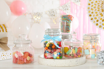 Candy bar. Many different sweets on white wooden table in festive decorated room