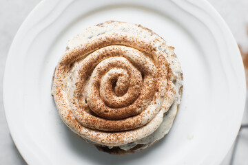 Overhead view of frosting coated cinnamon cookies, top view of cinnamon cookies with a vanilla cream frosting, process of making bakery style cookies