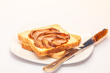 A wide angle view of a slice of bread with dulce de leche cream on top.