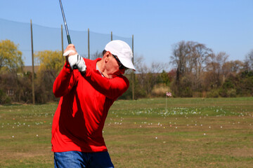 Practicing Golf Swings at a Sunny Driving Range With Plenty of Space