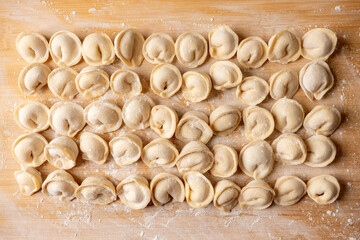 Raw dumplings in flour on the table. Russian national food. Shot from above.