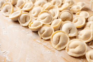 Raw dumplings in flour on the table. Russian national food. Selective focus.