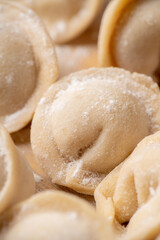 Raw dumplings in flour on the table. Russian national food. Selective focus.