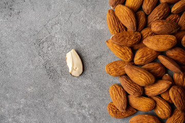 Pealed almond nuts on the gray concrete background. Healthy food. Shot from above.
