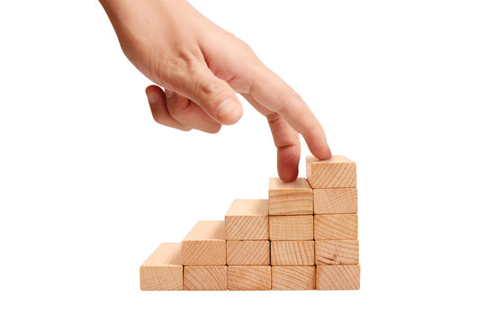 Building success hand placement on wooden blocks workshop skill development indoor environment close-up view growth concept