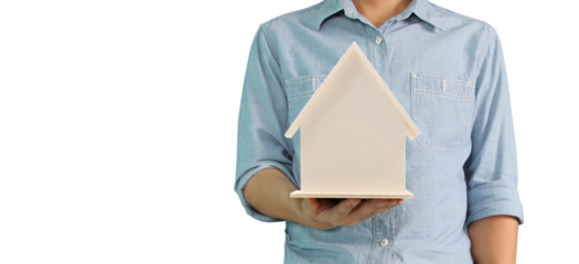 Person holding a model house indoors image of real estate concept bright environment close-up view symbolizing home ownership dreams
