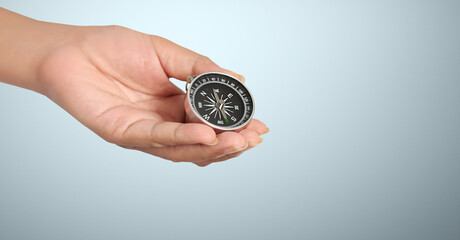 Hand holding compass symbolizing direction and navigation in an urban setting Business Concepts, Business Approaches and Success in Finance, Banking and Investment