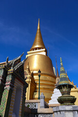 Fototapeta premium Golden Stupa and Ornate Temples at Wat Phra Kaew, Bangkok, Thailand