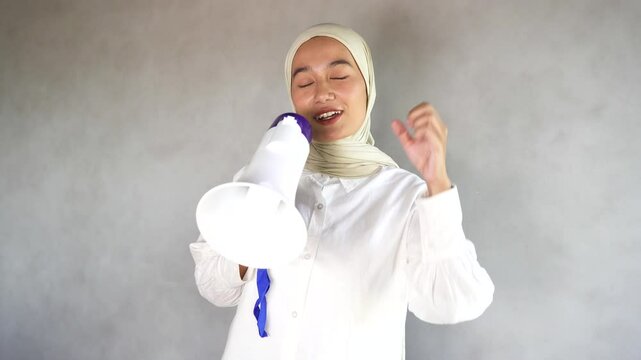 Footage of a woman holding a megaphone while encouraging