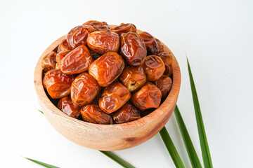 Dates fruit sukari or kurma sukari, in wooden bowl isolated on white background