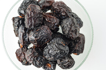 Dates fruit ajwa or kurma ajwa, in bowl isolated on white background