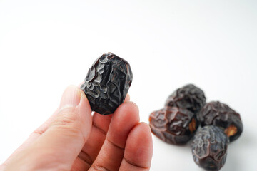 Dates fruit ajwa or kurma ajwa, in hand isolated on white background