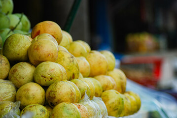 Ripe yellow guava fruit piled up in front of a fresh fruit shop in a traditional market, sweet, cheap and healthy yellow guava fruit, organic fresh fruit farmer