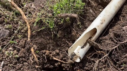 Camera pans to broken dug up gutter near residential home - Contractor work