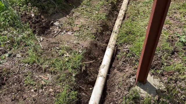 Camera pans to broken dug up gutter near residential home - Contractor work 2