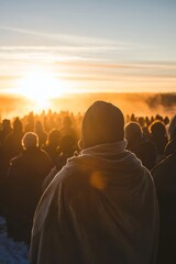 A peaceful sunrise lights up the horizon, bathing the gathering in soft, golden light. The congregation, dressed warmly, prays together as the sun rises. The mood is calm and reflective
